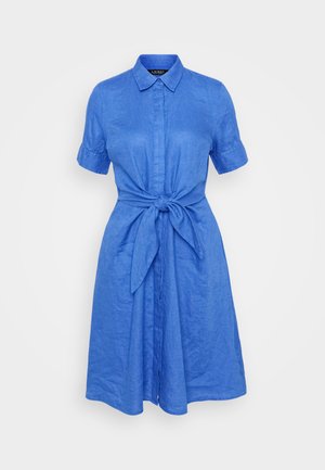 Vestido de linho azul com mangas curtas, frente com botões, colarinho e detalhe de cintura com laço. Textura suave e corte descontraído.