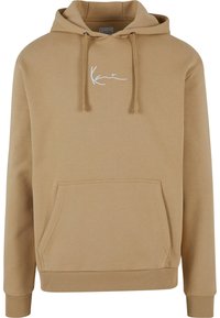 Beige hettegenser laget av mykt stoff, med en frontlomme, snøring i hetta og hvit brodert logo på brystet. Ribbestrikkede mansjetter og nederkant.
