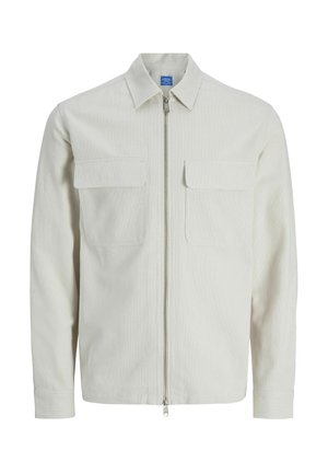 Šviesiai smėlio spalvos ilgomis rankovėmis striukė su smaigaliu apykakle, priekyje su užtrauktuku ir dviem krūtinės kišenėmis su atvartais.