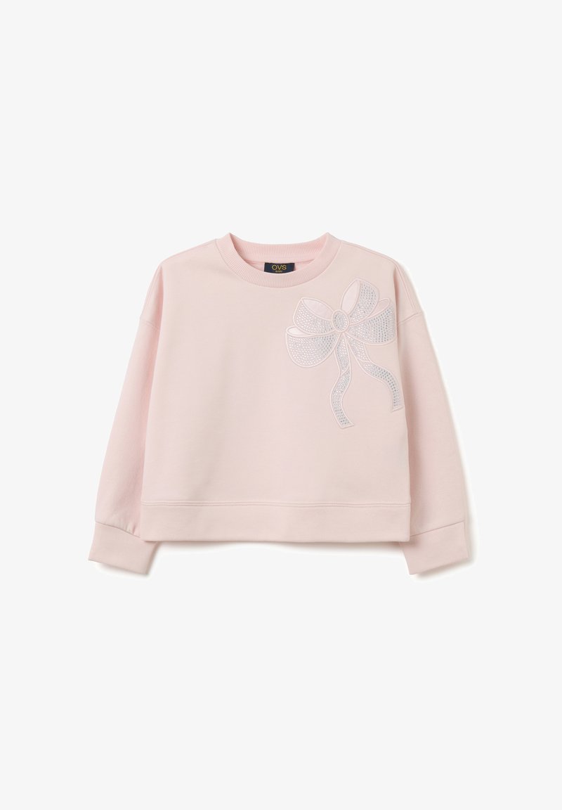 Felpa accorciata rosa chiaro in morbido tessuto con scollo rotondo, caratterizzata da un design di fiocco bianco con decorazioni sul lato sinistro.