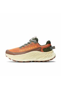 Zapatilla de running de malla naranja y verde con cordones grises, suela media gruesa blanca y suela de tracción de goma, y logo de "new balance" en el lateral.