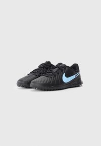 Chaussures de sport noires avec un dessus en synthétique texturé, des lacets noirs et un swoosh Nike bleu. Elles disposent d'une semelle en caoutchouc avec de petits crampons pour l'adhérence.