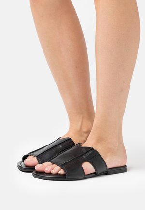 Zwarte leren sandalen met een open teen ontwerp, voorzien van brede banden en uitsparingen voor ventilatie. Platte zool met een gestructureerde afwerking.