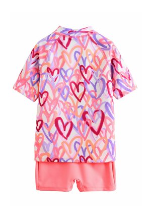 T-shirt met korte mouwen en een meerkleurig hartpatroon in roze, paars en oranje, gecombineerd met effen roze zwembroek.