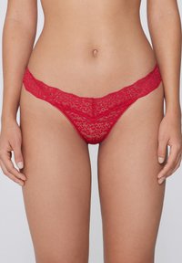 Rode kanten string met een bloemenpatroon, voorzien van een gegolfde tailleband en dunne bandjes. Lichtgewicht en delicate textuur.
