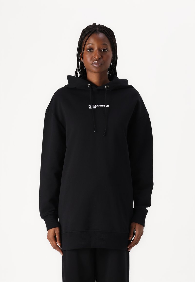 Black hoodie made of cotton, featuring a front kangaroo pocket, drawstring hood, and embroidered logo text in white. Relaxed fit with ribbed cuffs.