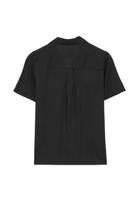 Blouse noire à manches courtes avec empiècement au dos et pli central, dotée d'un col décontracté et d'un design simple et épuré.