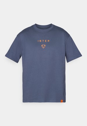 T-shirt en coton bleu marine à manches courtes, avec le texte "INTER" orange et le logo sur la poitrine, et une petite étiquette orange à l'ourlet.