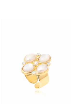 Bague en or avec quatre perles blanches ovales disposées en forme de fleur, accentuée par de petites pierres blanches rondes sur l'anneau.
