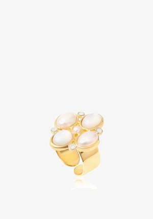 Bague en or avec quatre perles blanches ovales disposées en forme de fleur, accentuée par de petites pierres blanches rondes sur l'anneau.