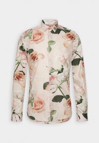 Lange mouwen shirt van lichtgewicht stof, met een lichtroze achtergrond en grote rozenbloempatronen in zachte tinten en groene bladeren.