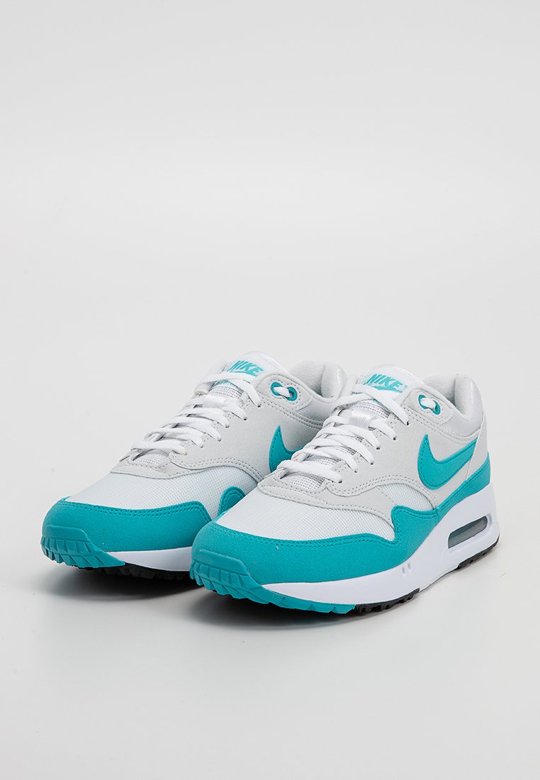 Witte en teal Nike sneakers hebben een gestructureerde bovenkant met een gladde afwerking, een gewatteerde kraag en zichtbare luchtkussens in de zool.
