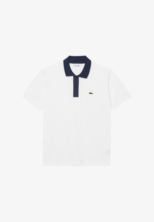 Camisa polo blanca de algodón, con un cuello azul marino y tapeta de tres botones. Incluye un pequeño logotipo bordado en verde en el lado izquierdo del pecho.