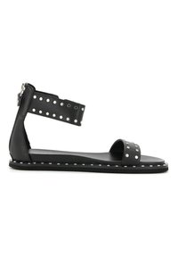 Sandali flat neri con una texture in pelle liscia, dettagli borchiati sulla cintura alla caviglia e sullo spazio per il dito, dal design minimalista e con chiusura a zip.