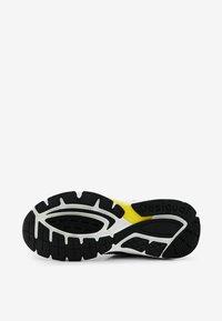 Suela exterior de goma negra con patrón de banda de rodadura texturizada, con una entresuela blanca y un detalle amarillo. Marca "Desigual" en el lateral.