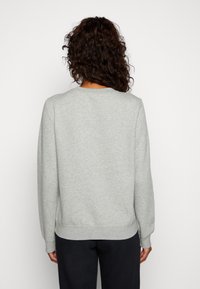 Sweatshirt gris à manches longues, col rond, avec des poignets et un ourlet côtelés. Texture douce ; sans motifs ni accents visibles.