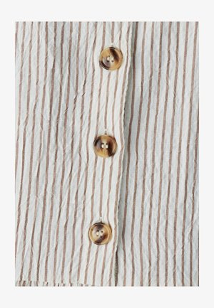 Balts brūni svītrains audums ar krokainu tekstūru, uz kura ir četri apaļi, spoži pogas ar divu caurumu dizainu.