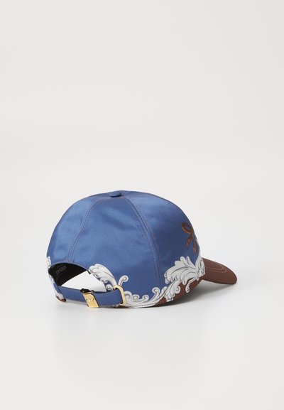Casquette avec une couronne en satin bleu et une visière marron. Présente des broderies florales blanches et du matériel doré sur la sangle arrière ajustable.