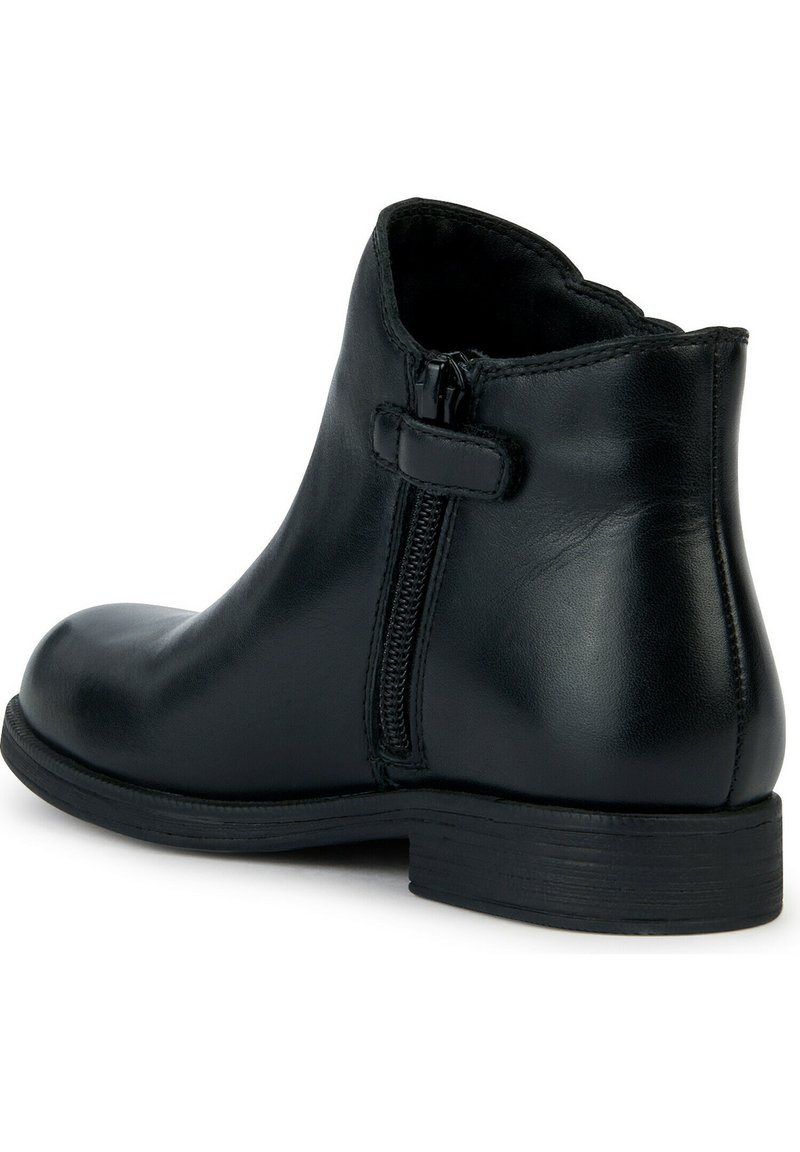 Stivale alla caviglia in pelle nera con tacco basso, chiusura con cerniera e dettagli di cucitura discreti lungo le cuciture. Texture liscia e lucida.