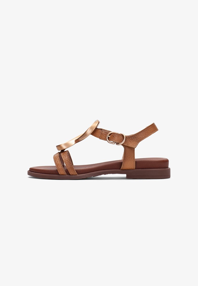 Sandale plate marron avec des brides en cuir texturé, un accent décoratif métallique, une boucle à la cheville et une semelle rembourrée.