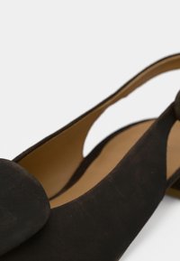 Μαύρα ψηλοτάκουνα παπούτσια από σουέντ με ανοιχτή φτέρνα, μυτερή μύτη και λείο εσωτερικό επένδυση. Διαθέτουν ελαφρώς κυρτή, κομψή σιλουέτα.