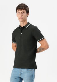 Tamnozeleni polo majica od pamuka, s rebrastim ovratnikom s bijelim prugama, kratkim rukavima i slim fit dizajnom.