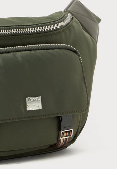 Borsa in nylon verde oliva con hardware argento, texture imbottita, chiusura con zip e una tracolla decorativa con strisce multicolori. Presenta il logo del marchio.