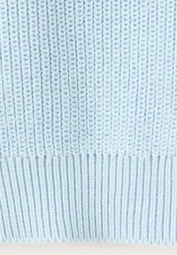 Tissu tricoté bleu clair avec un motif de côtes verticales et un ourlet côtelé plus épais au bord inférieur.
