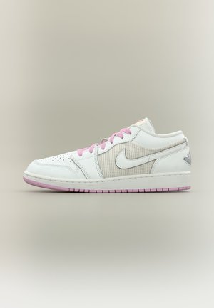 Baskets basses blanches Nike avec lacets et semelle roses, zone des orteils perforée et panneau latéral texturé avec logo Nike Swoosh.