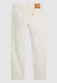 Jean beige Levi's vu de dos avec deux poches, coutures visibles, un patch en cuir de la marque et une petite étiquette rouge sur la poche droite.