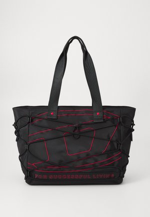Sac fourre-tout noir avec accents rouges, fabriqué à partir de matériau texturé. Il dispose d'un filet externe et de deux poignées, avec un logo sur le devant.
