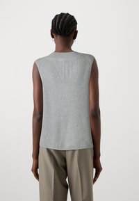 Lichtgrijze mouwloze top met ribbeltextuur, rechte zoom en ronde halslijn. Gemaakt met beige broek. Achteraanzicht weergegeven.