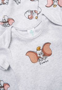 Light gray baby clothes with printed illustrations of Dumbo the elephant wearing a yellow hat and the name "Dumbo" on the front.
