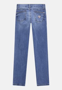 Modré džínové kalhoty se rovný střihem, dvěma zadními kapsami a logem na pravé kapse. Mají vybledlou strukturu a standardní šití.