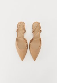 Korkeakorkoiset nude-slingback-kengät, joissa on terävä kärki, sileä nahkapinta, joustava hihna ja pehmustettu pohja, suunniteltu tiiviiseen siluettiin.