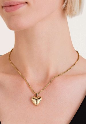 Collar de cadena en tono dorado con un colgante en forma de corazón acanalado, que presenta un diseño retorcido y una textura suave.