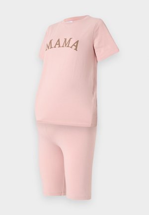 Rozi set za trudnice od udobnog pamučnog materijala, koji sadrži majicu kratkih rukava s natpisom "MAMA" ispisanim smešnom bojom, uz odgovarajuće šorts do kolena.