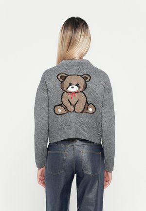 Grijze gebreide trui met een cropped ontwerp, featuring een bruine berenafbeelding met een rode strik op de achterkant. Zachte textuur en ribbelrand.
