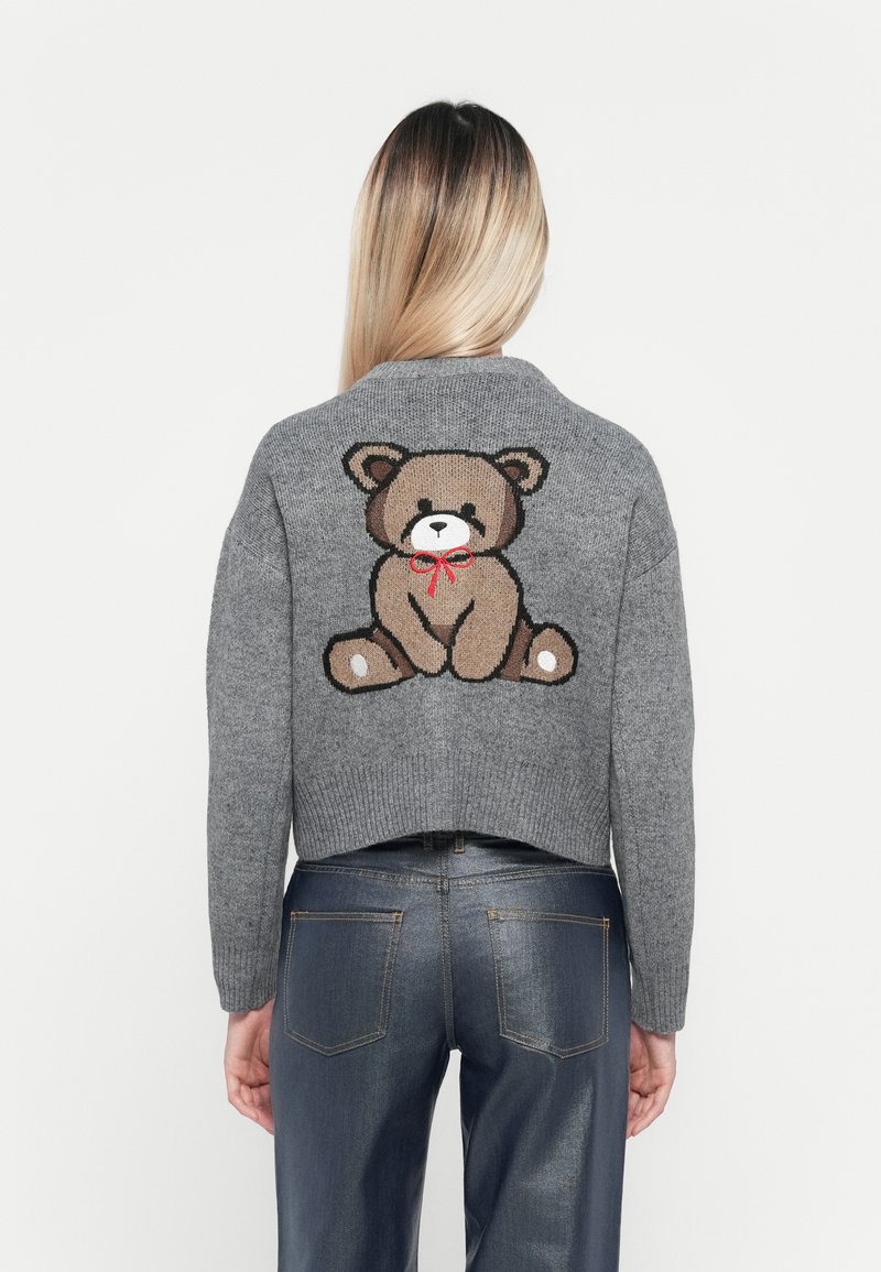 Maglione grigio a maglia con design corto, caratterizzato da una grafica di un orso bruno con un fiocco rosso sul retro. Tessuto morbido e bordi a coste.