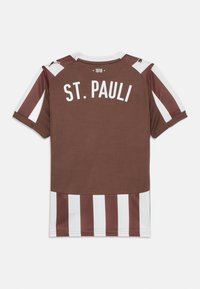 Brązowa sportowa koszulka z białymi i bordowymi pionowymi paskami, z napisem "ST. PAULI" w kolorze białym na plecach, z okrągłym dekoltem.