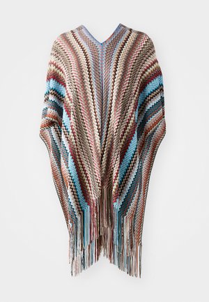 Poncho multicolore avec un motif en zigzag bleu, beige, rouge et marron, avec des bords frangés et un design en V.
