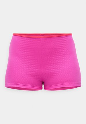 Shorts de sport roses avec une texture côtelée, présentant une taille contrastante rouge. Conçus pour le confort et la flexibilité dans le mouvement.