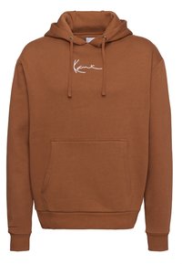 Hnedá mikina s kapucňou vyrobená z mäkkej tkaniny. Obsahuje predné vrecko, šnúrky na stiahnutie a biele vyšívané logo. Žebrované manžety a spodný lem.