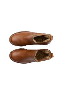 Bottines en cuir marron avec un bout rond, des panneaux latéraux élastiques et une doublure douce et moelleuse. Dotées d'une languette à l'arrière pour un enfilage facile.