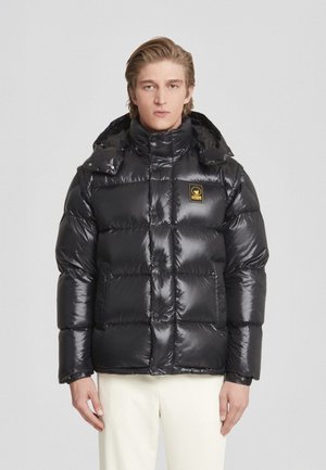 Giacca puffa nera con superficie lucida, design trapuntato, colletto alto e cappuccio attaccato. Presenta una piccola etichetta logo sul petto.