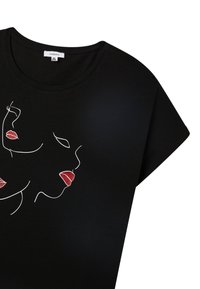 T-shirt in cotone nero con collo a girocollo, caratterizzato da un disegno a linee bianche di volti e labbra rosse. Maniche corte, texture morbida e vestibilità comoda.