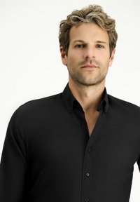 Zwarte overhemd met knopen, gemaakt van een gladde stof, met een klassieke kraag en een knopenlijst, met een getailleerde pasvorm en zonder zichtbare patronen.