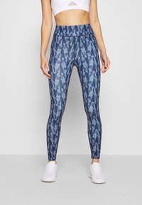 Legíny s vysokým pasem v modrém ombre vzoru s přiléhavým střihem. Vyrobené z elastického materiálu, s plochými švy a bez viditelného brandingu.