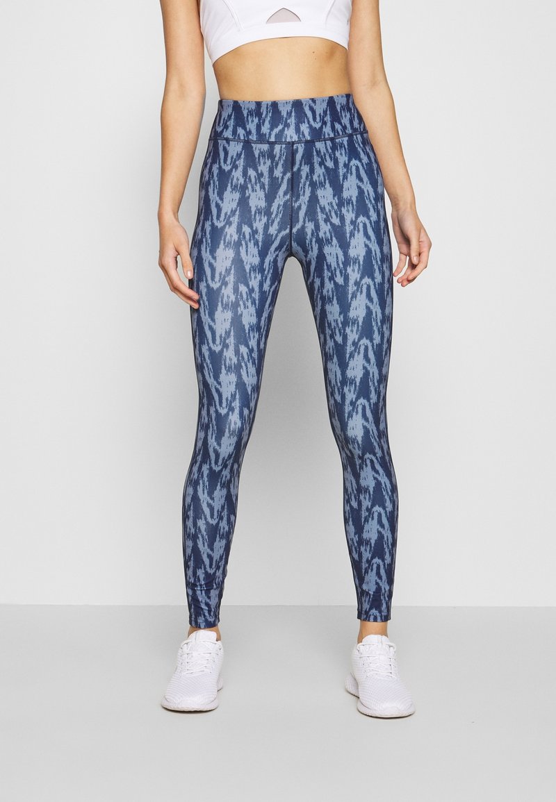 Legíny s vysokým pasem v modrém ombre vzoru s přiléhavým střihem. Vyrobené z elastického materiálu, s plochými švy a bez viditelného brandingu.