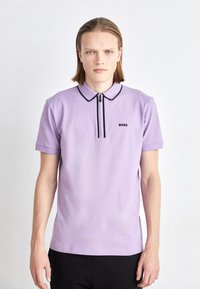 Fialová polokošile s černými akcenty, krátkými rukávy a předním zapínáním na půl zip. Obsahuje malé logo "BOSS" na levé hrudi. Hladká textura.